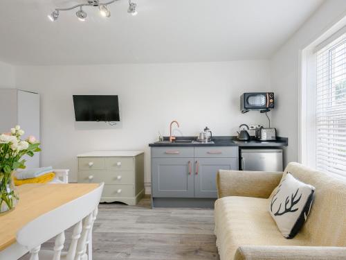 a living room with a table and a kitchen at The Gardens in Santon