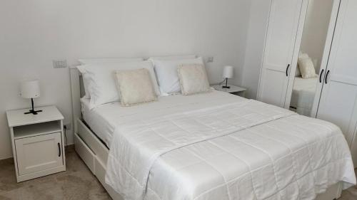 a white bed with white sheets and pillows in a bedroom at Villa Incanto Pina - Torre Canne in Torre Canne