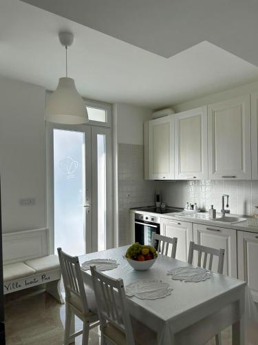 a kitchen with a table with a bowl of fruit on it at Villa Incanto Pina - Torre Canne in Torre Canne