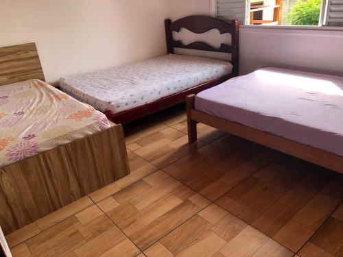 due letti in una stanza con pavimenti in legno di Chácara / Casa de Campo a Bragança Paulista