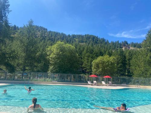 un groupe de personnes nageant dans une piscine dans l'établissement Plein Centre, sublime et confortable, 6 personnes, 2 chambres, Plein Centre, luxueux 6 personnes, 2 chambres , terrasse, vue époustouflante, Tout pédestre, piste à 100m, parking couvert, à Isola