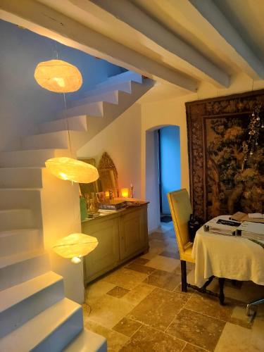 a room with a table and a staircase with lights at Perche King's Bedroom in MaisonNomadeChic in Cour-Maugis-sur-Huisne
