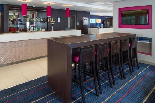 a bar with black stools in a restaurant at Holiday Inn Express London - Wandsworth by IHG in London