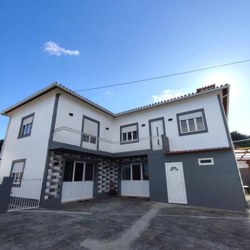a large white house with a parking lot at Rainha do Mar AL 3436 in Fontinhas