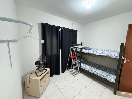 a room with two bunk beds with black curtains at Perto do aeroporto, estádio e Praia dos Buritis in Palmas