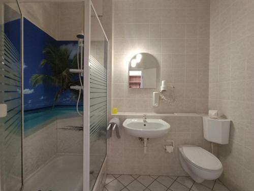 a bathroom with a toilet and a sink and a shower at Gasthaus & Hotel Grünhof in Frankfurt Oder