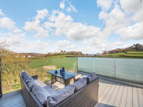 a patio with a table and chairs on a deck at Blodfryn in Llandudno Junction