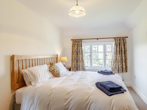 a bedroom with a large white bed with a window at Mark Farmhouse in Bradwell on Sea