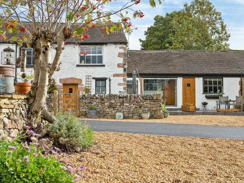 a white house with a stone wall and a yard at Lavender Cottage - Uk4061 in Buxton