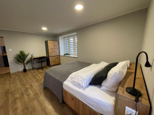 a bedroom with a bed and a desk in it at Apartament blisko Rynku "Kamienica" in Dębica
