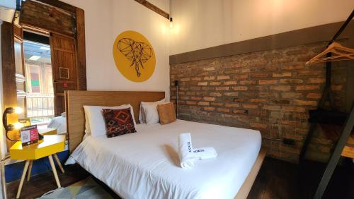 a bedroom with a bed and a brick wall at Socialtel Candelaria Bogotá in Bogotá