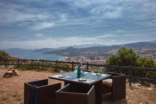 a table and chairs with a view of the ocean at Casa Bianca in LʼÎle-Rousse