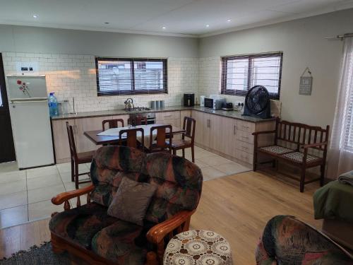 a living room with a kitchen and a table and chairs at Kardoesie in Piet Retief
