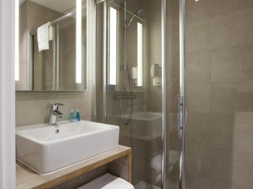 a bathroom with a sink and a shower at ibis Styles Nieuwpoort in Nieuwpoort