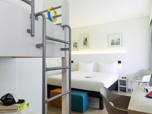 a room with a bunk bed and a bed and a desk at ibis Styles Nieuwpoort in Nieuwpoort