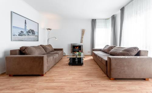 a living room with two brown couches and a fireplace at Vineta in Ostseebad Koserow