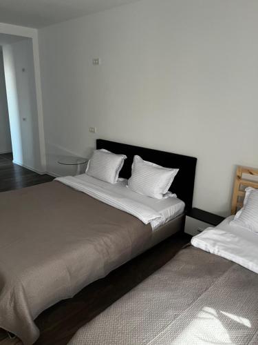 a bedroom with two beds with white pillows at The Lakehouse Snagov Near Therme in Vlădiceasca