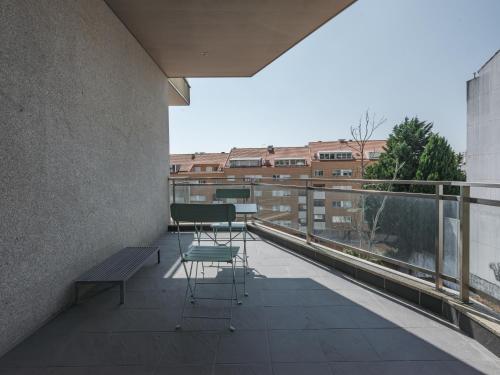 a balcony with a bench and chairs on a building at Dom Carlos Villa in Vila Nova de Gaia