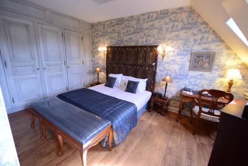 a bedroom with a bed and a desk in it at Cit'Hotel Le Relais du Boisniard in Chambretaud