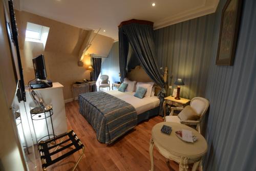 a hotel room with a bed and a table at Cit'Hotel Le Relais du Boisniard in Chambretaud
