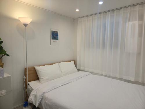 a bedroom with a white bed and a window at 오픈특가-역삼역7분,강남세브란스병원,코엑스,롯데월드,국립중앙박물관,홍대,명동,넷플릭스 in Seoul