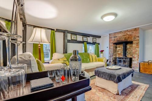 een woonkamer met een bank en een open haard bij Boldshaves Cottage in Woodchurch