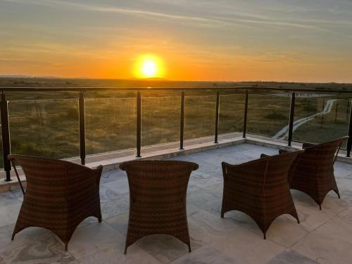 einen Balkon mit Stühlen und einem Sonnenuntergang im Hintergrund in der Unterkunft Villa Di Lucca in Prea