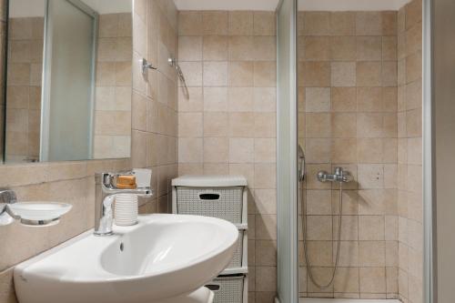 ein Badezimmer mit Waschbecken und Dusche in der Unterkunft Golden Horizon Villas Santorini in Akrotiri