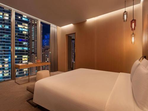 a bedroom with a white bed and a large window at Rixos Premium Dubai JBR in Dubai