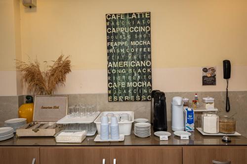 a counter with plates and cups on top at Scenarium Hotel in Recife
