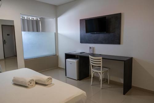 a bedroom with a desk and a bed with a chair at Scenarium Hotel in Recife