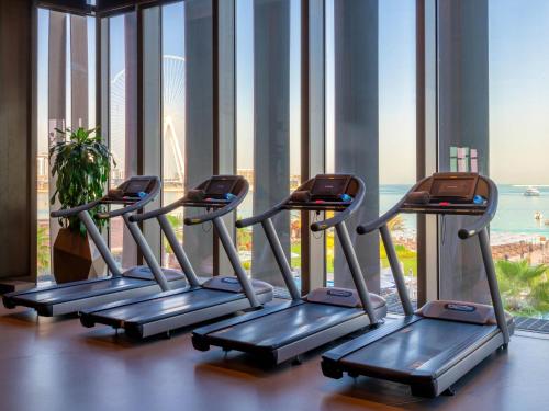 a row of treadmills in a gym with a large window at Rixos Premium Dubai JBR in Dubai
