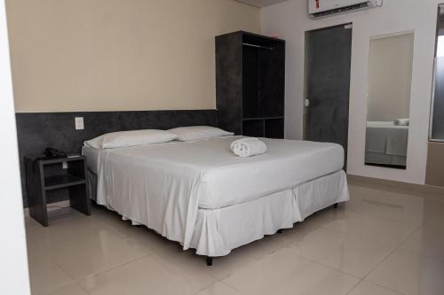 a bedroom with a large white bed and a bathroom at Scenarium Hotel in Recife