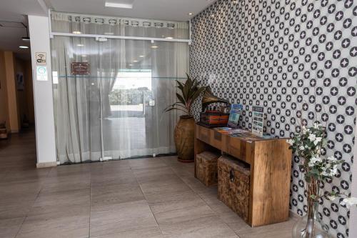 a lobby with a wall with a patterned wall at Scenarium Hotel in Recife