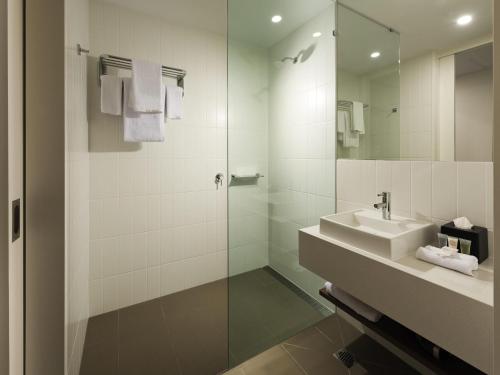 a bathroom with a sink and a glass shower at ibis Brisbane Airport in Brisbane