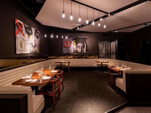 a dining room with tables and chairs and lights at Rixos Premium Dubai JBR in Dubai