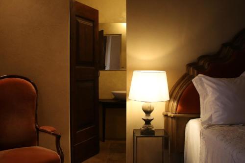 a bedroom with a bed with a lamp and a chair at Castello di Viano in Viano
