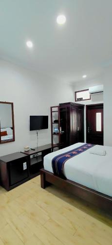 a bedroom with a bed and a flat screen tv at Bethara Hotel Syariah Lampung in Tanjungkarang