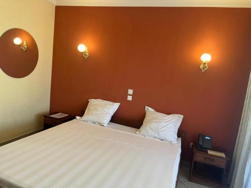a bedroom with a bed with two pillows on it at HOTEL MENABE in Morondava