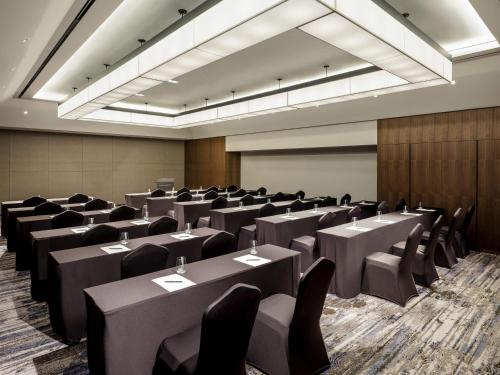 a conference room with tables and chairs and a projection screen at Novotel Suites Ambassador Seoul Yongsan in Seoul
