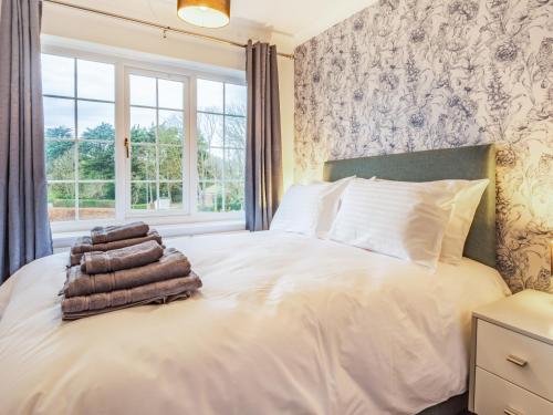a bedroom with a bed with towels on it at The Gables in Sewerby