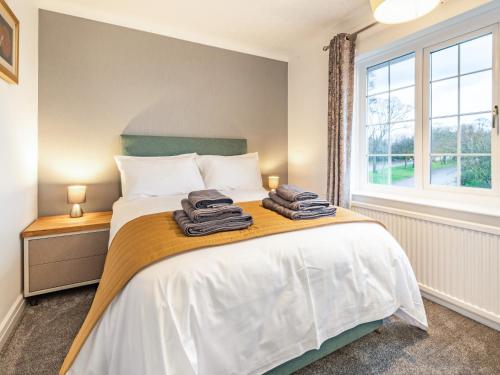 a bedroom with a bed with towels on it at The Gables in Sewerby