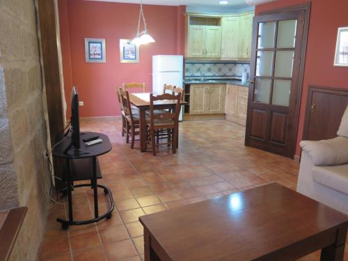 a living room with a table and a kitchen at La Casa del Seise in Baeza