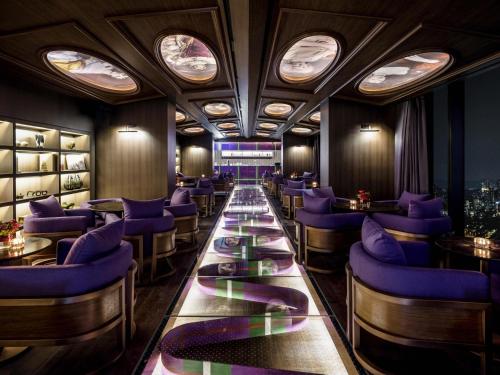 a restaurant with purple chairs and a bar at ibis Styles Ambassador Seoul Yongsan in Seoul