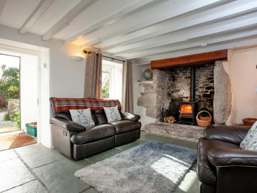 a living room with a couch and a fireplace at The Farm House in Porkellis