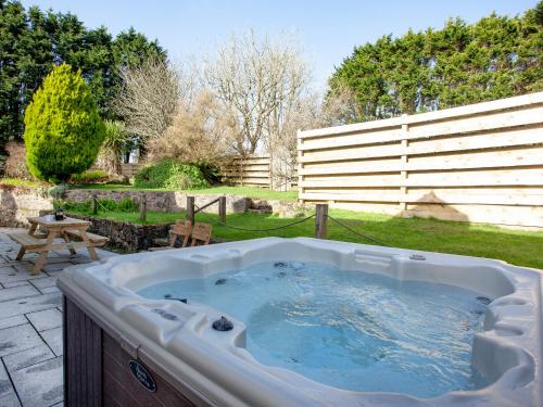 a jacuzzi tub in a yard with a fence at The Farm House in Porkellis