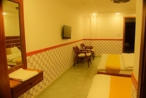 una habitación con dos camas y una mesa y sillas en Bless-Inn & Restaurant, en Islamabad