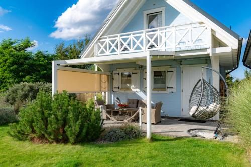 a house with a wrap around porch with a deck at Domki nad morzem Otulone Słońcem in Rowy