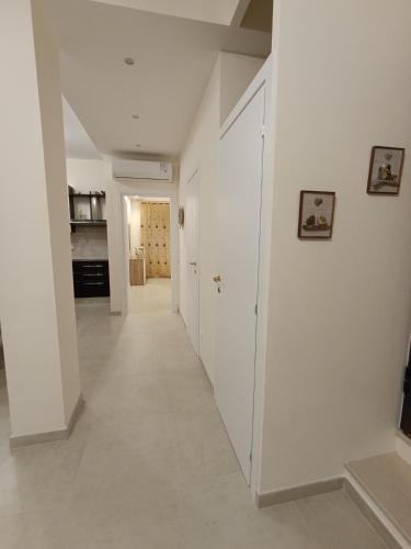 a hallway with white walls and a white floor at Residenza Orchidea in Tarquinia