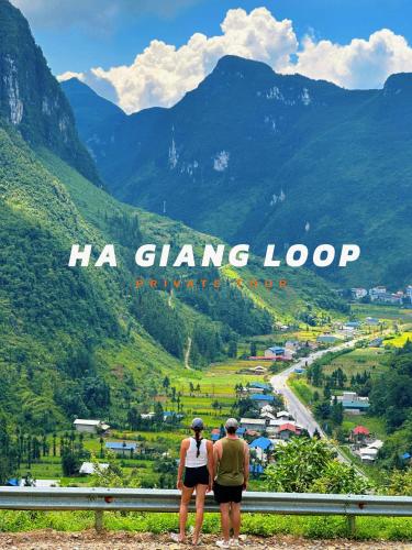two people standing on top of a mountain overlooking a valley at Ha Giang Hostel in Ha Giang
